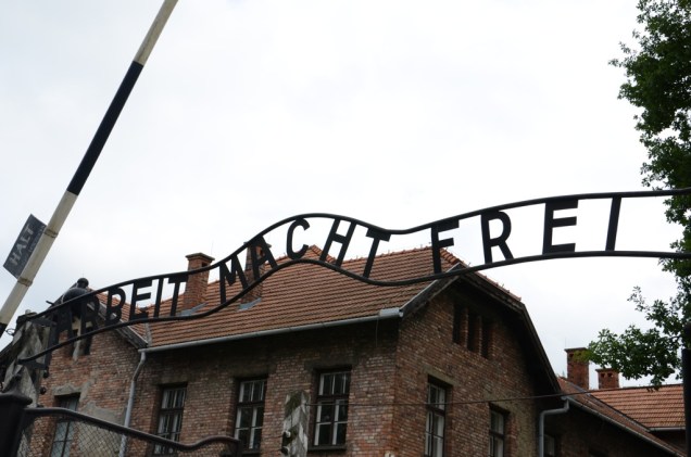 A inscrição <em>Arbeit Macht Frei</em>, literalmente O Trabalho Liberta, era frequentemente colocado na entrada dos campos de concentração nazistas, como este em Auschwitz I, o mais famoso de todos. Roubado em 2009 e posteriormente recuperado, o portão hoje apresenta uma réplica.