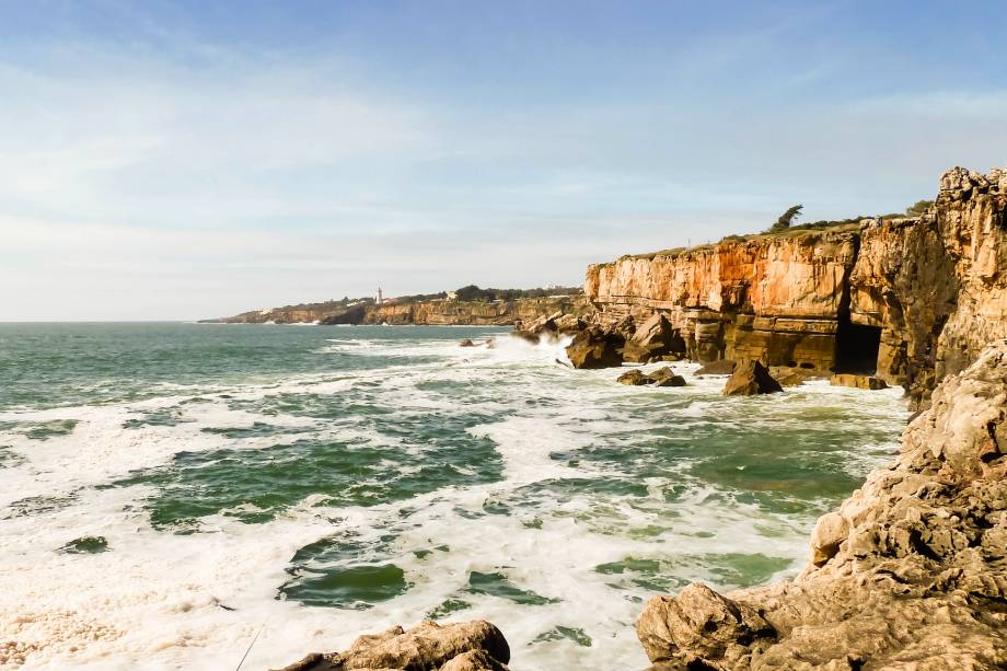 Há quem inclua Cascais no roteiro de Lisboa pela proximidade da cidade: são 30km. A graça da parada é o encontro com o Atlântico. No calor dá até para pegar praia, mas mesmo se o tempo não é dos melhores você pode encher a vista com as mansões de verão, bem glamourosas, e com os pescadores que não se incomodam com a chuva de respingos de água do mar que encontram as rochas da Boca do Inferno (foto).  <a href="https://www.booking.com/searchresults.pt-br.html?aid=332455&sid=605c56653290b80351df808102ac423d&sb=1&src=index&src_elem=sb&error_url=https%3A%2F%2Fwww.booking.com%2Findex.pt-br.html%3Faid%3D332455%3Bsid%3D605c56653290b80351df808102ac423d%3Bsb_price_type%3Dtotal%26%3B&ss=Cascais%2C+Regi%C3%A3o+de+Lisboa%2C+Portugal&checkin_monthday=&checkin_month=&checkin_year=&checkout_monthday=&checkout_month=&checkout_year=&no_rooms=1&group_adults=2&group_children=0&b_h4u_keep_filters=&from_sf=1&ss_raw=Cascais&ac_position=0&ac_langcode=xb&dest_id=-2162360&dest_type=city&place_id_lat=38.69689&place_id_lon=-9.42045&search_pageview_id=dc577bb30b4402c2&search_selected=true&search_pageview_id=dc577bb30b4402c2&ac_suggestion_list_length=5&ac_suggestion_theme_list_length=0" target="_blank" rel="noopener"><em>Busque hospedagens em Cascais</em></a>