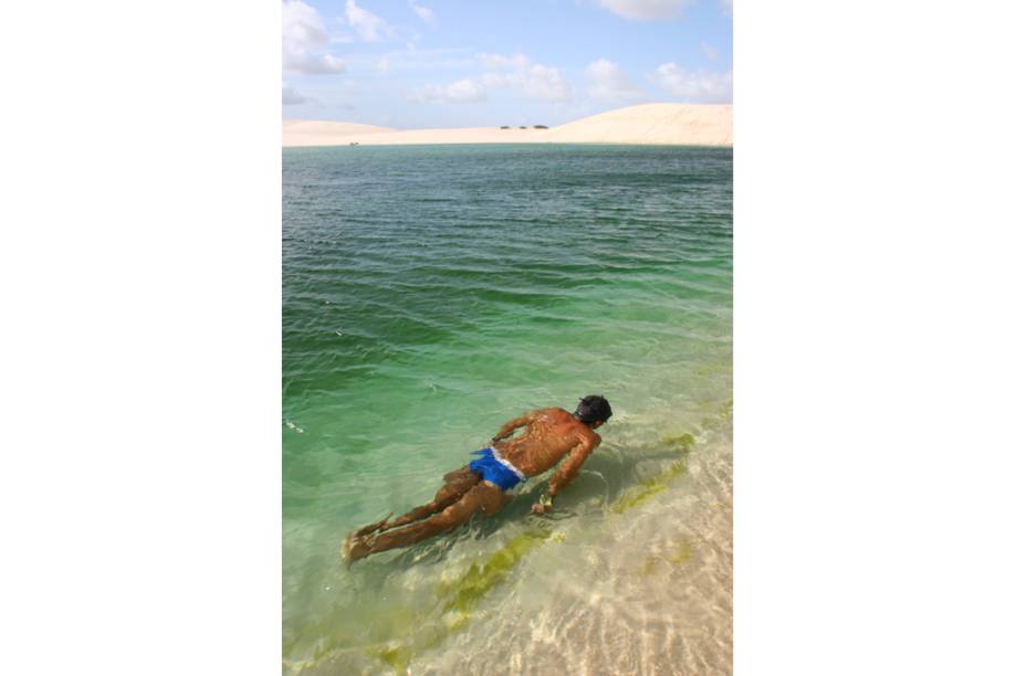 Homem nadando na Lagoa da Gaivota no <a href="http://viajeaqui.abril.com.br/estabelecimentos/br-ma-barreirinhas-atracao-parque-nacional-dos-lencois-maranhenses" rel="Parque Nacional dos Lençóis Maranhenses" target="_blank">Parque Nacional dos Lençóis Maranhenses</a>