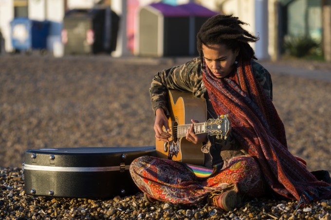 Garota toca violão em praia de Brighton, Inglaterra Flickr