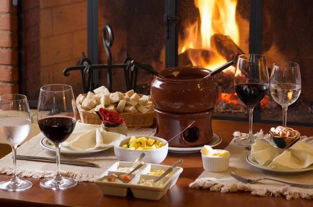 Mesa de fondue na Pousada Mirante da Colyna: prato icônico nas hospedagens e restaurantes do distrito