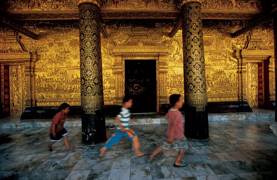Acostumados com o magnífico cenário, meninos passam com pressa na frente dos muros dourados de Wat Mai, templo do século 18 ornamentado com cenas detalhadas da vida de Buda. A designação de Patrimônio da Humanidade abrange todo o vilarejo de Luang Prabang, uma antiga capital real