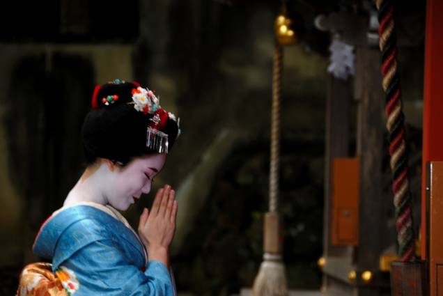 Aprendiz de geisha, conhecidas como maiko, faz oração no santuário xintoísta Matsuo Taisha, em Kyoto