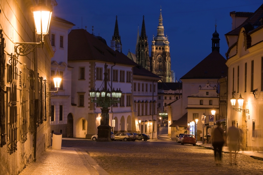 A cidade de Praga convida as pessoas a andar de mãos dadas, admirando a encantadora luz sobre o histórico casario