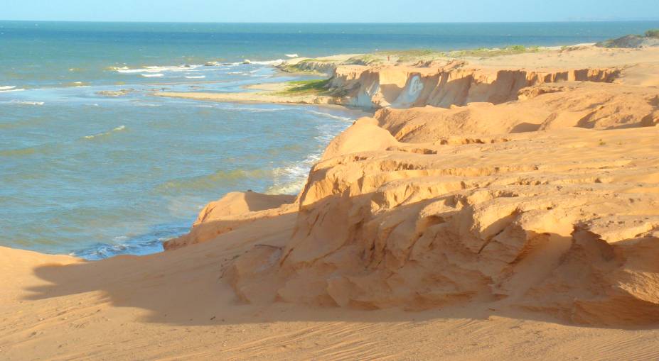 O conjunto formado por mar esverdeado, falésias e dunas é a maior beleza do distrito, a 180 quilômetros de Fortaleza