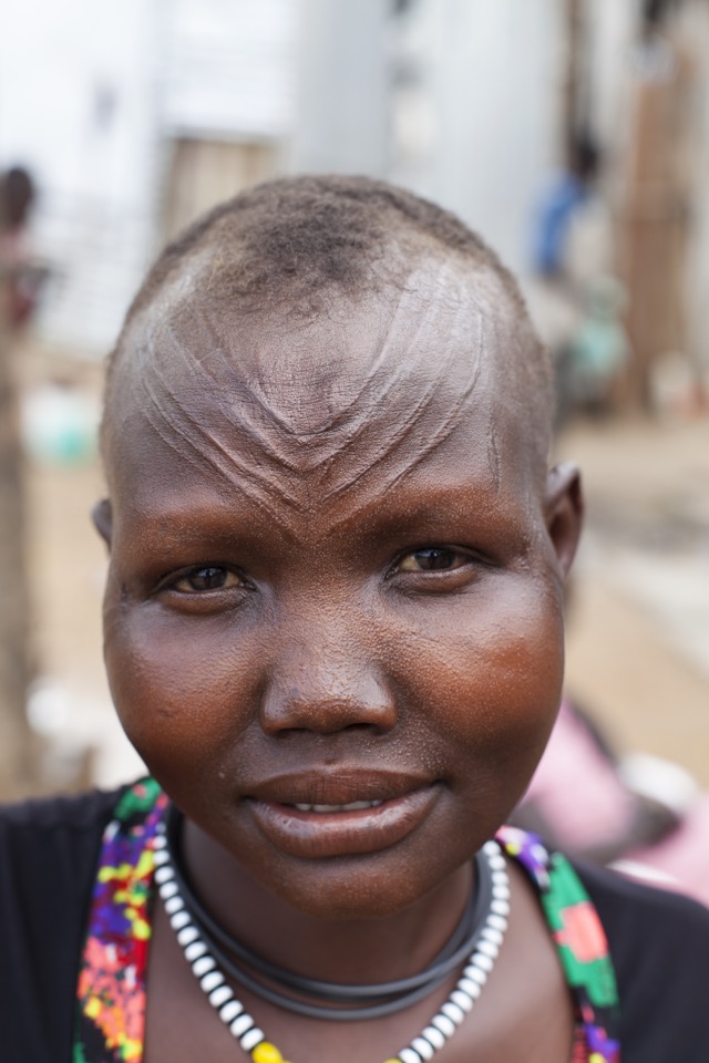 Retrato de uma mulher no Sudão do Sul. As cicatrizes na testa são "usadas" como adorno 
