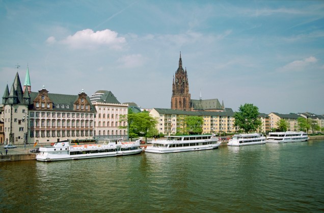 Barcos se acumulam ao longo do lago principal da cidade de Frankfurt. Ao fundo, a beleza da Catedral de São Bartholomeu 