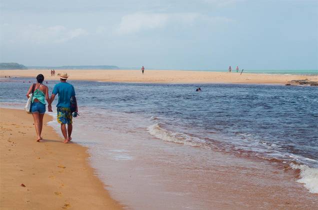 O rio deságua no mar, deixando a água mais escura O rio deságua no mar, deixando a água mais escura