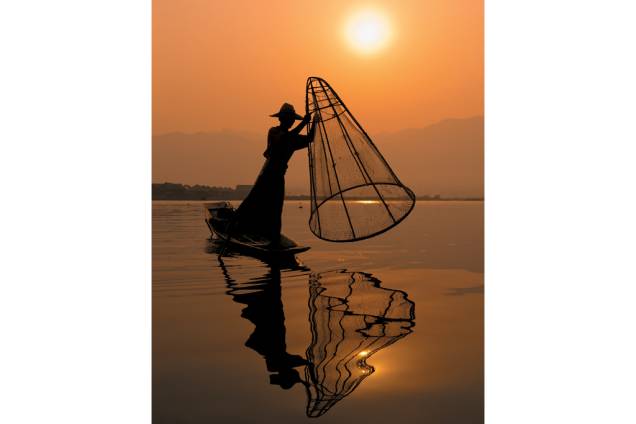 O tradicional estilo de remar com o pé no Lago Inle O tradicional estilo de remar com o pé no Lago Inle