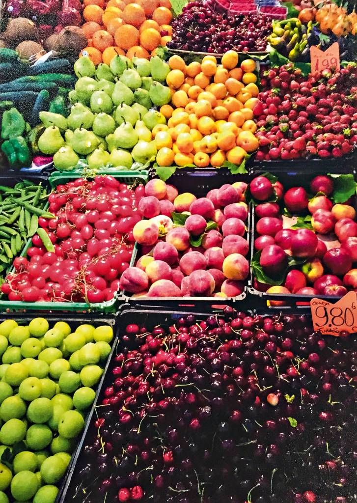 Uma variação de frutas se estende em caixas perante o leitor, entre elas cerejas, peras, morangos e pêssegos.