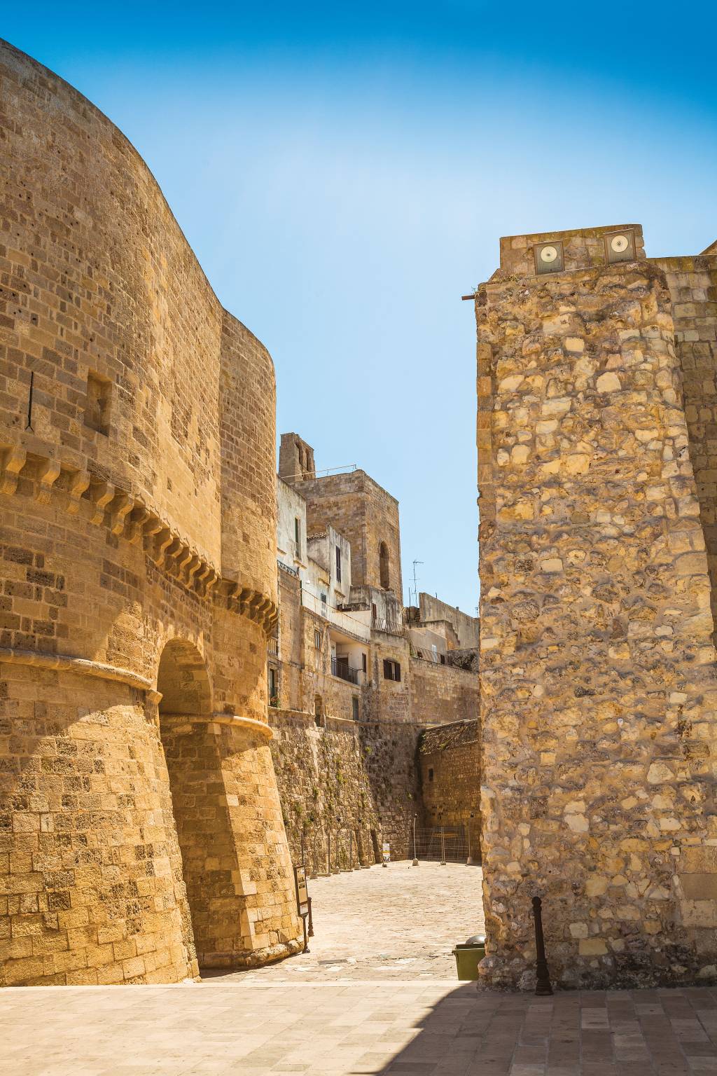 Um beco com altas paredes de tijolos, as quais formam uma seção da muralha de Gallipoli