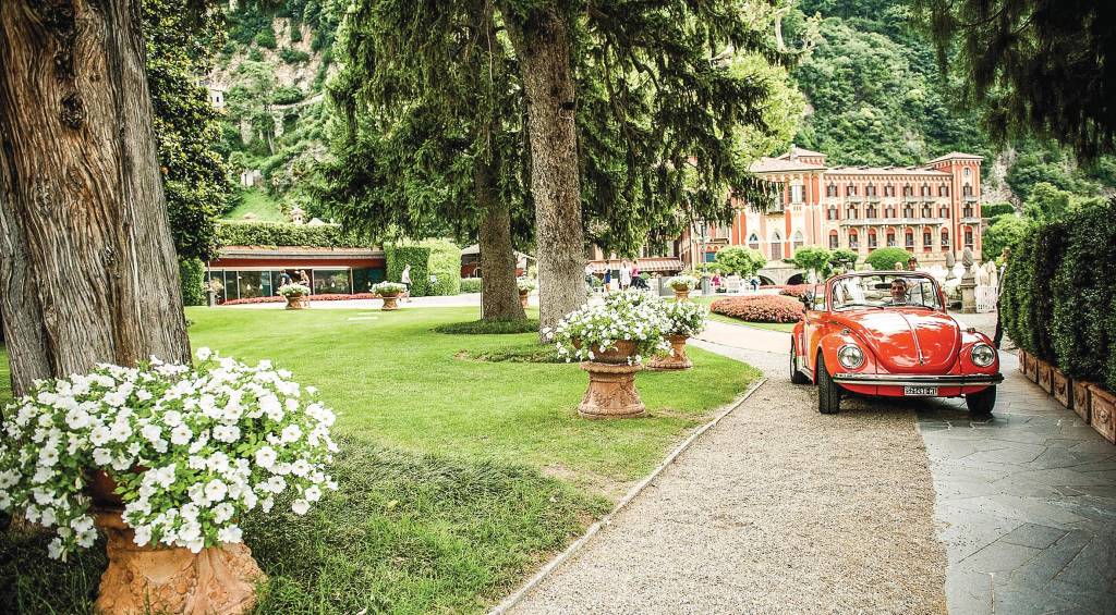 Villa d'Este, Cernobbio, Lago Como, Itália Um fusca conversível percorre o caminho de saída do suntuoso jardim do hotel Villa d'Este, que se encontra ao fundo