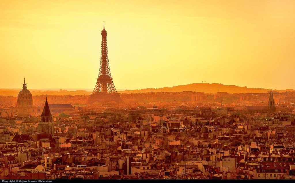 Uma imagem da cidade de Paris, com a Torre Eiffel ao fundo e à direita contra um céu extenso