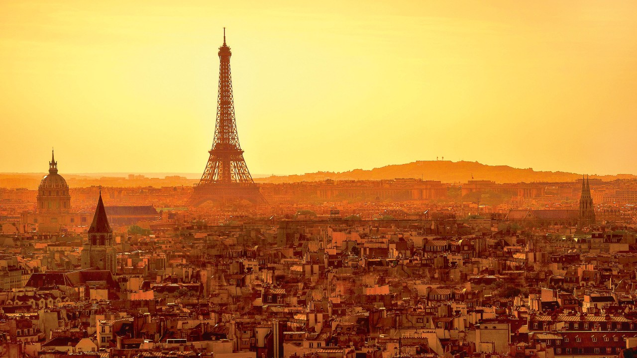 Uma imagem da cidade de Paris, com a Torre Eiffel ao fundo e à direita contra um céu extenso