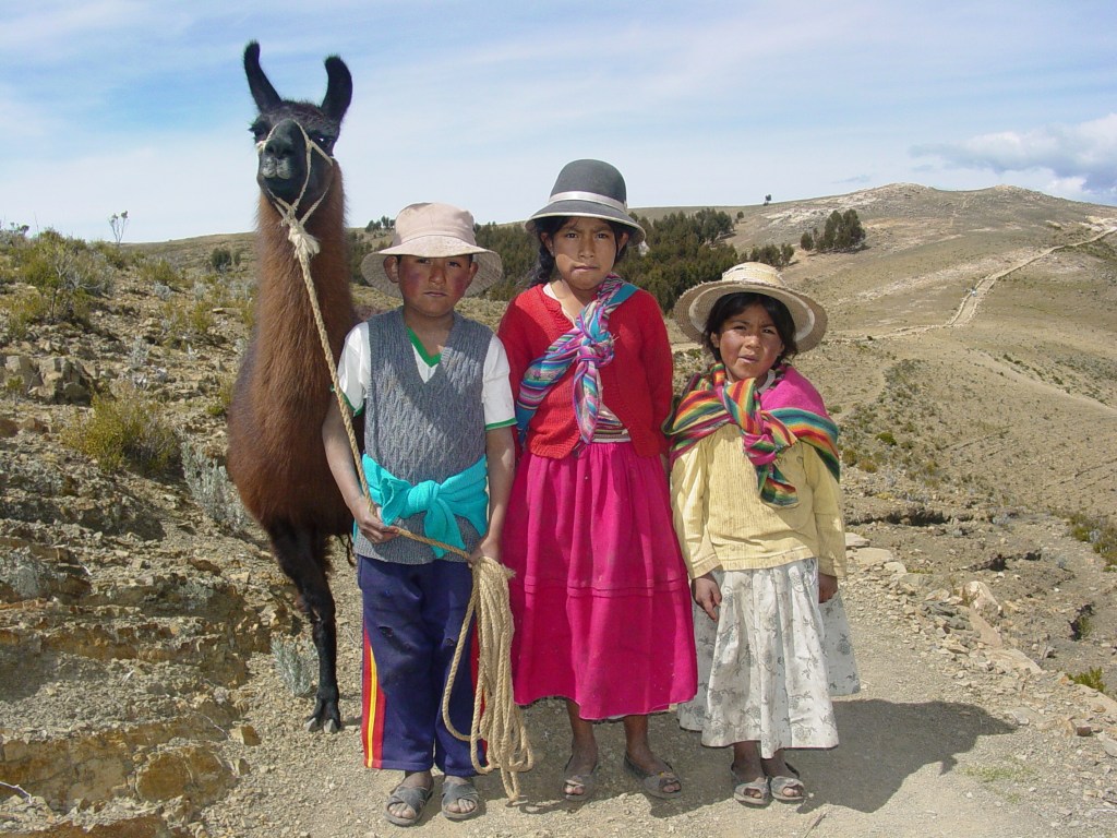 Crianças indígenas bolivianas e lhama na Isla del Sol, no Lago Titicaca, na Bolívia