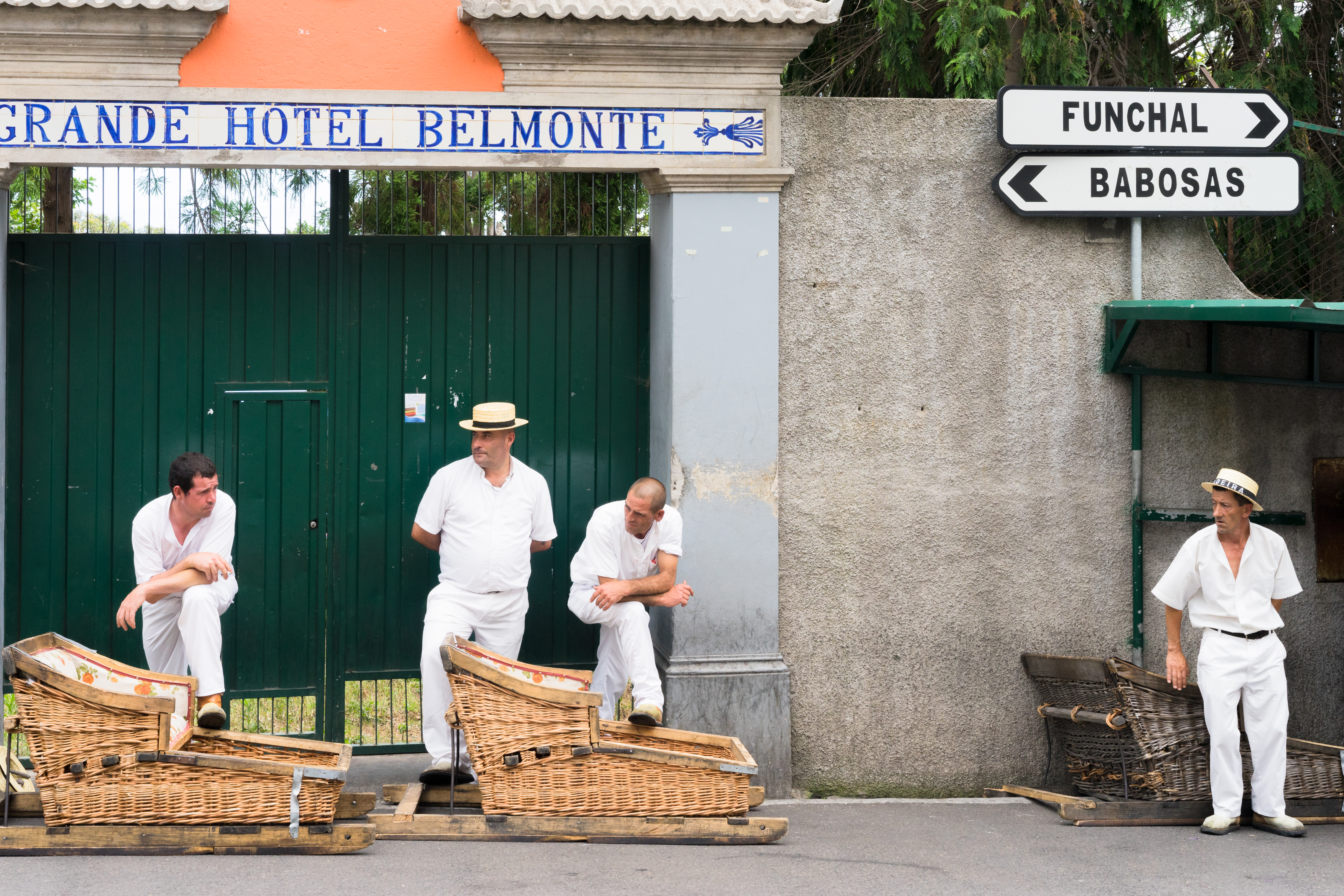 Condutores esperam turistas na Ilha da Madeira, Portugal, para transportá-los em carrinhos de tobogã feitos de vime