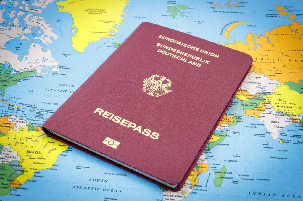 Passaporte alemão em cima de mapa múndi