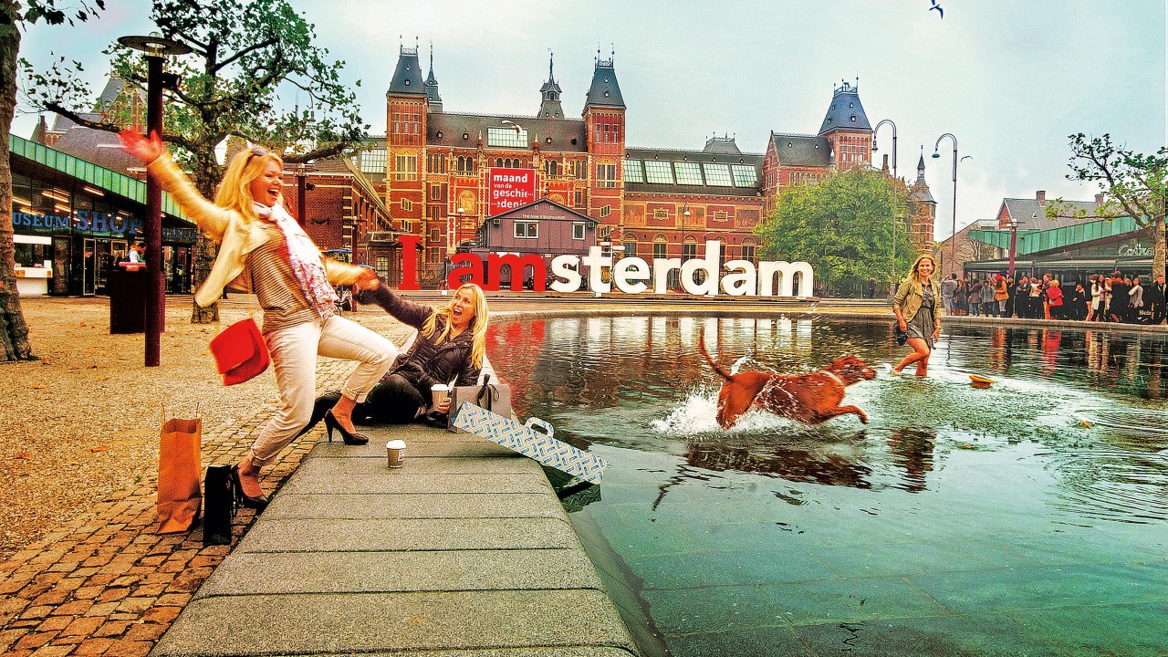 Três mulheres e um cachorro se divertem em frente ao Rijksmuseum, molhando os pés no pequeno lago em frente e rindo