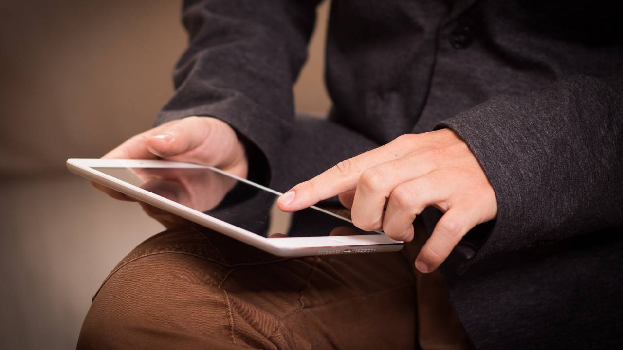 Mãos masculinas mexendo em tablet