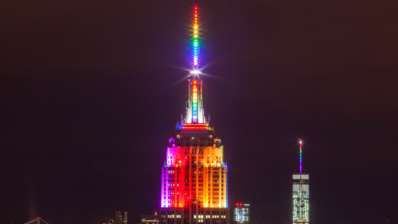 Torre em Nova York iluminada com as cores do orgulho LGBT à noite