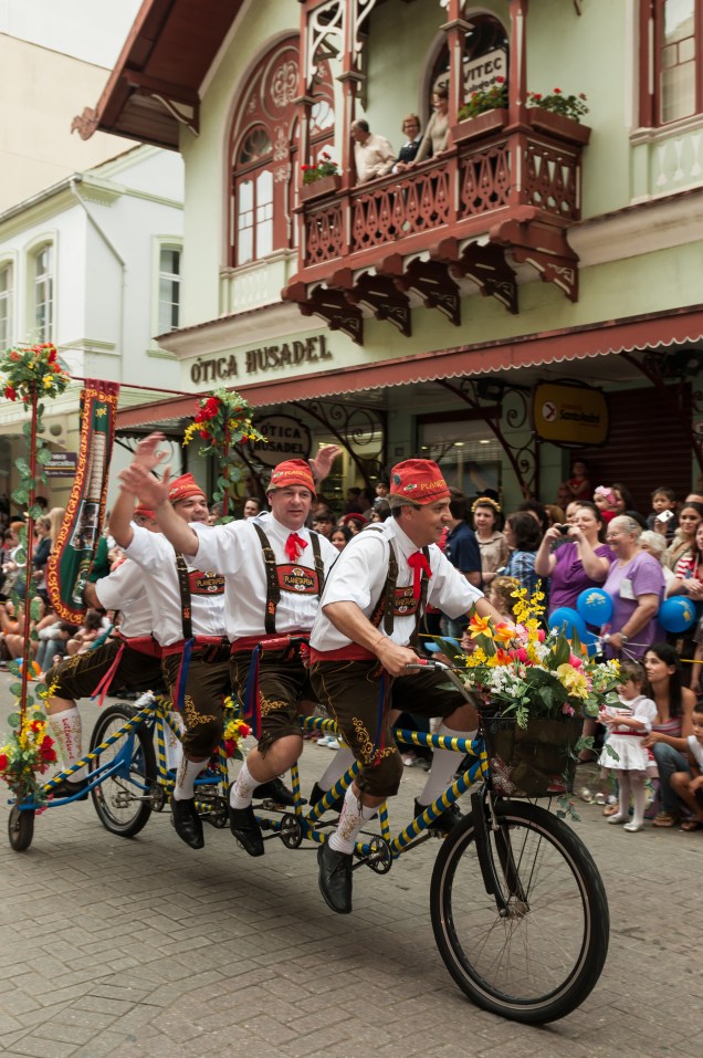 Grupo de amigos em uma bicicleta compartilhada durante uma evento de rua em Blumenau