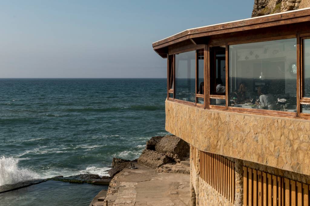 O restaurante: debruçado sobre a piscina e o mar