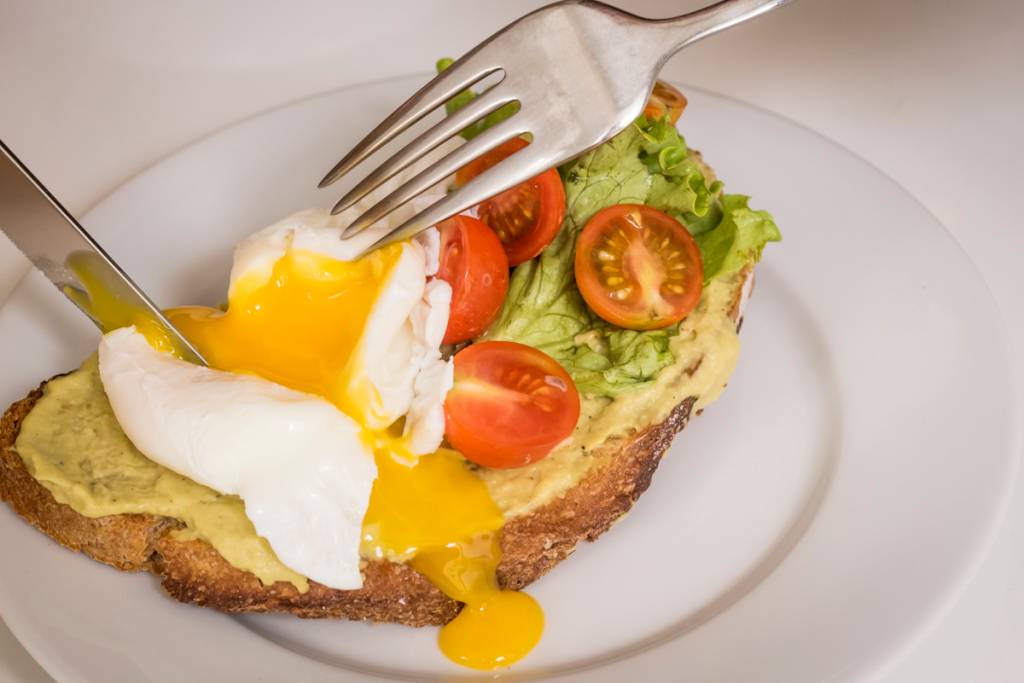 A tosta de abacate com ovo escalfado: quem resiste a esta gema?