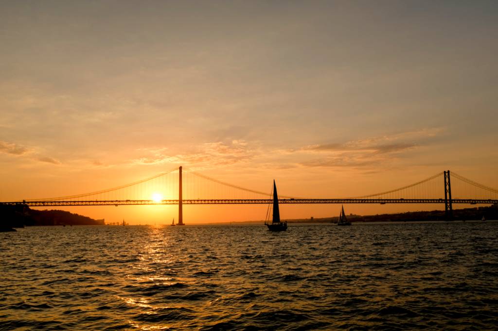 A Ponte 25 de Abril vista do Cais do Ginjal: espetáculo ao pôr-do-sol