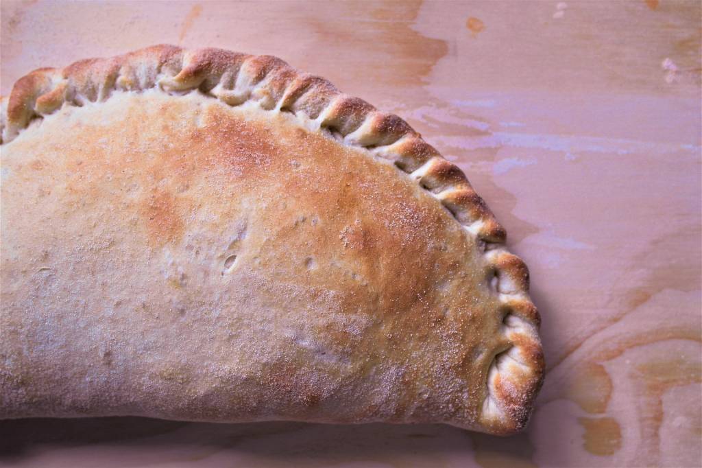 Calzone, Itália A imagem mostra uma uma pizza que foi dobrada ao meio de forma que a massa se fechasse em uma meia lua.