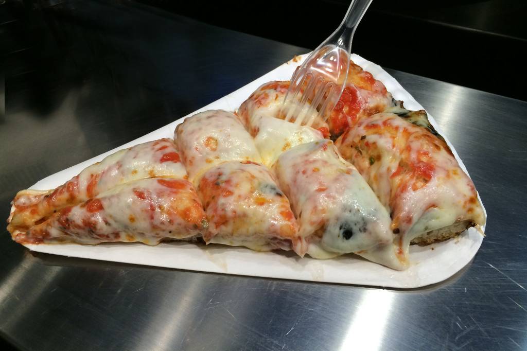 Pizza alla Milanese, Itália A imagem mostra uma pizza coberta por queijo que parece ter gomos de recheio sobre a camada de cobertura.