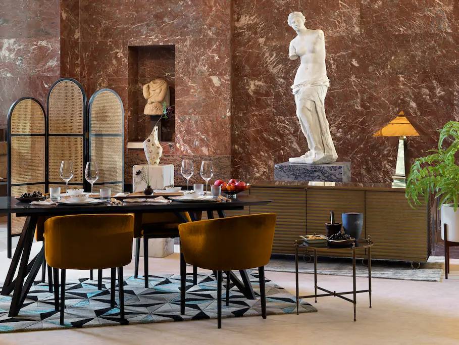 Mesa de jantar montada em frente a estátua de Vênus de Milo, no Museu do Louvre, em Paris