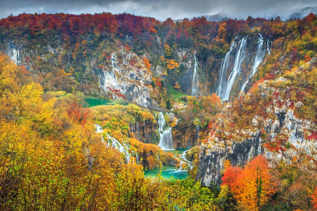 No outono, no Parque Nacional dos Lagos de Plitvice, o contraste entre as cores quentes e o azul dos lagos é surreal. Crédito: