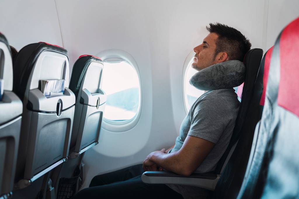 Homem no assento mais próximo a janela do avião