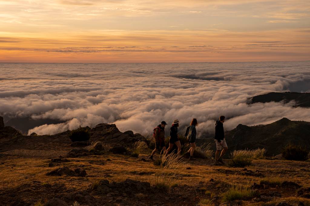 Quatro pessoas caminham acima das nuvens no Pico do Areeiro, Ilha da Madeira