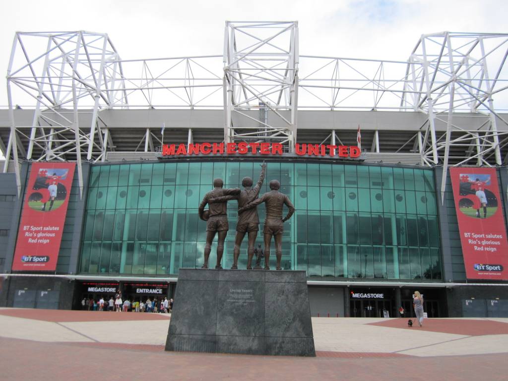 Entrada do estádio de Old Trafford, com a estátua dos jogadores George Best, Denis Law e Sir Bobby Charlton