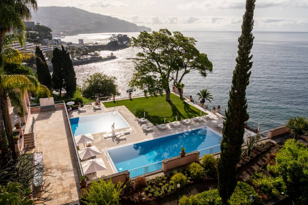 156 Duas piscinas, uma árvore e o mar no hotel Reid's Palace, na Ilha da Madeira