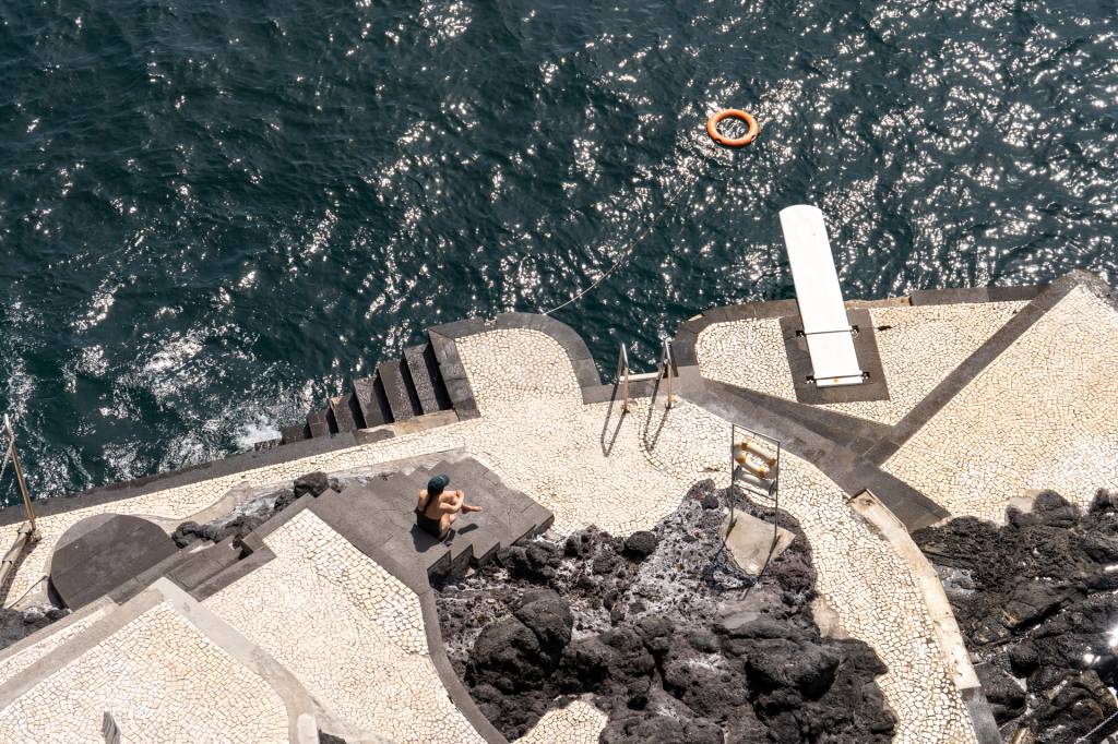 Beira-mar do hotel Reid's Palace, na Ilha da Madeira, com pedras e uma plataforma com escada e trampolim