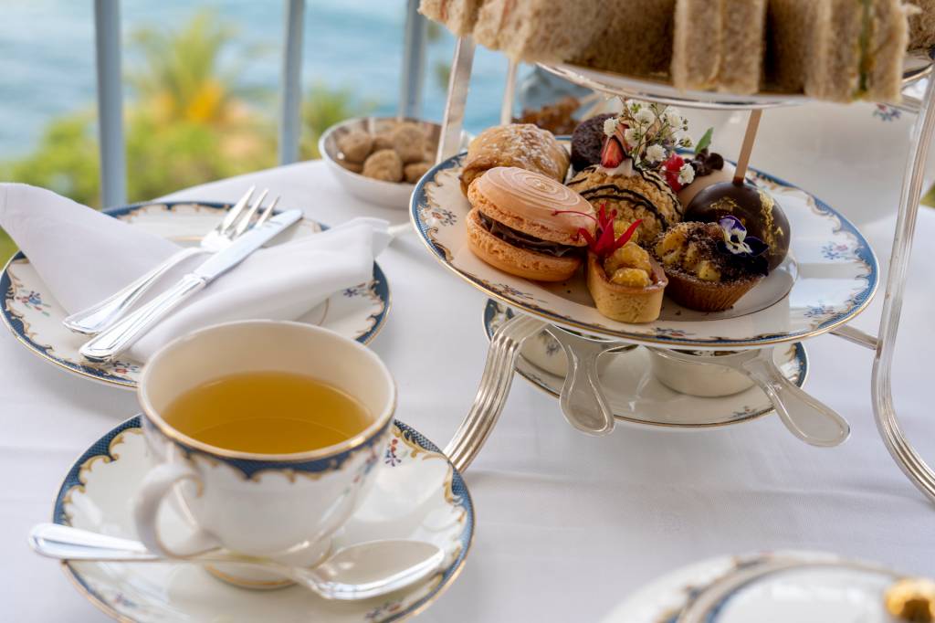 161 Xícara de chá e prato de doces em cima de uma mesa com vista do mar no hotel Reid's Palace, na Ilha da Madeira