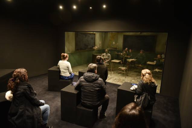 Na instalação" Classroom", os visitantes observam seu reflexo por um vidro que cria uma cena diferente