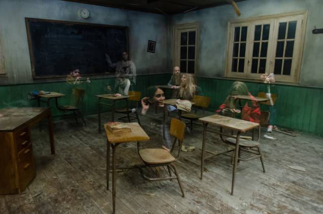 A cena reproduzida causa a impressão de que os visitantes são fantasmas em meio a uma sala de aula decadente