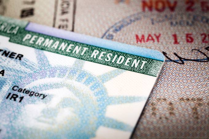 A Green Card lying on an open passport, close-up, full frame