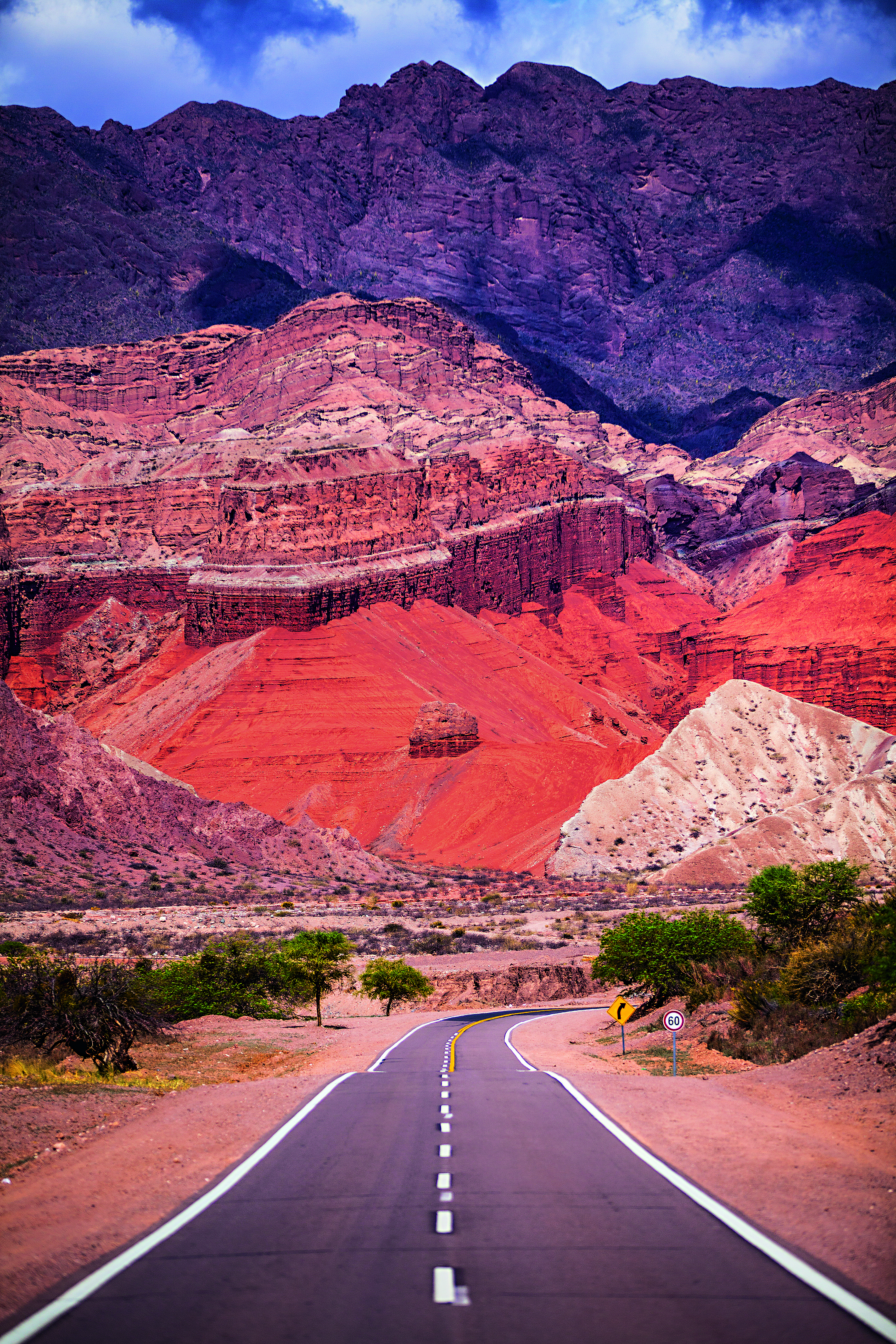 Uma estrada se estende pelo meio de paredões rochosos avermelhados