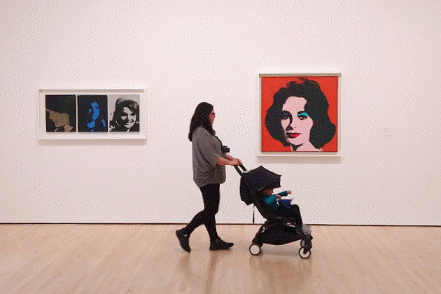 Mulher passeia com carrinho de bebê em museu