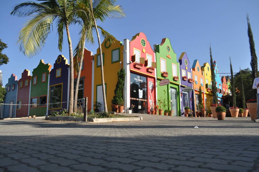 A imagem mostra várias lojas em estilo arquitetônico holandês colorido.