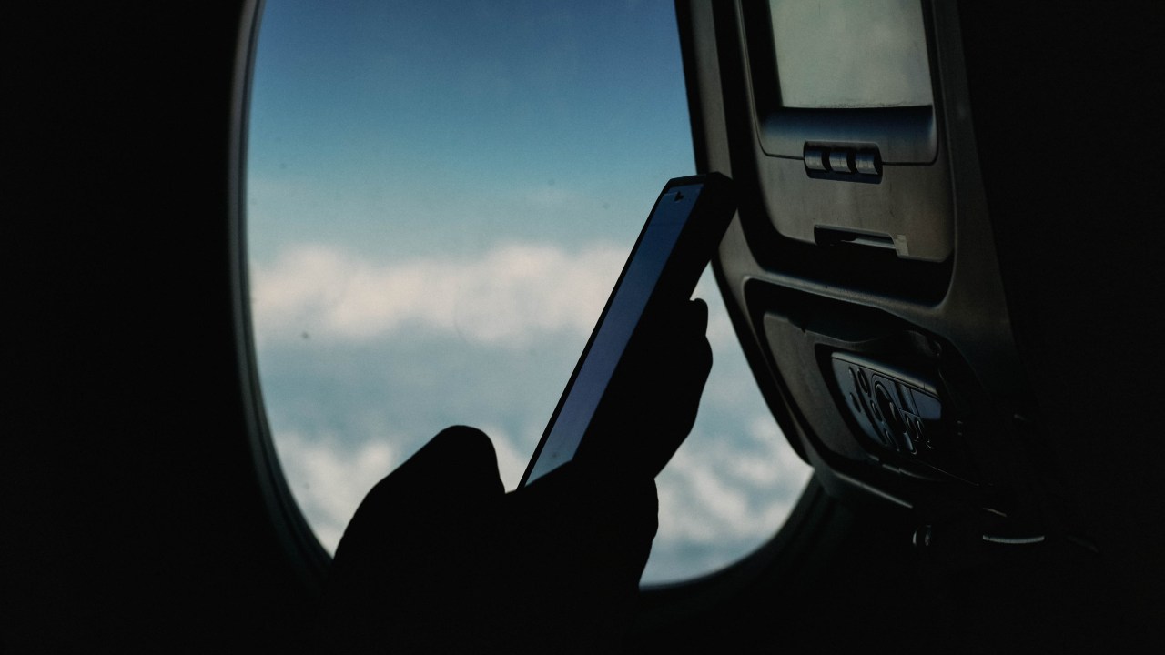 Pessoa usando celular dentro do avião