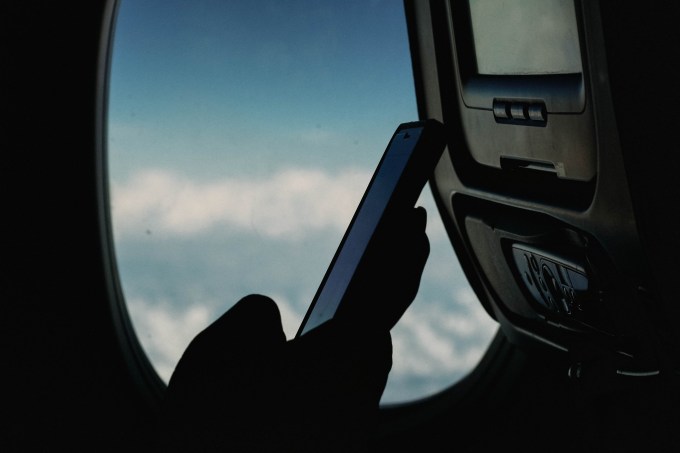 Pessoa usando celular dentro do avião