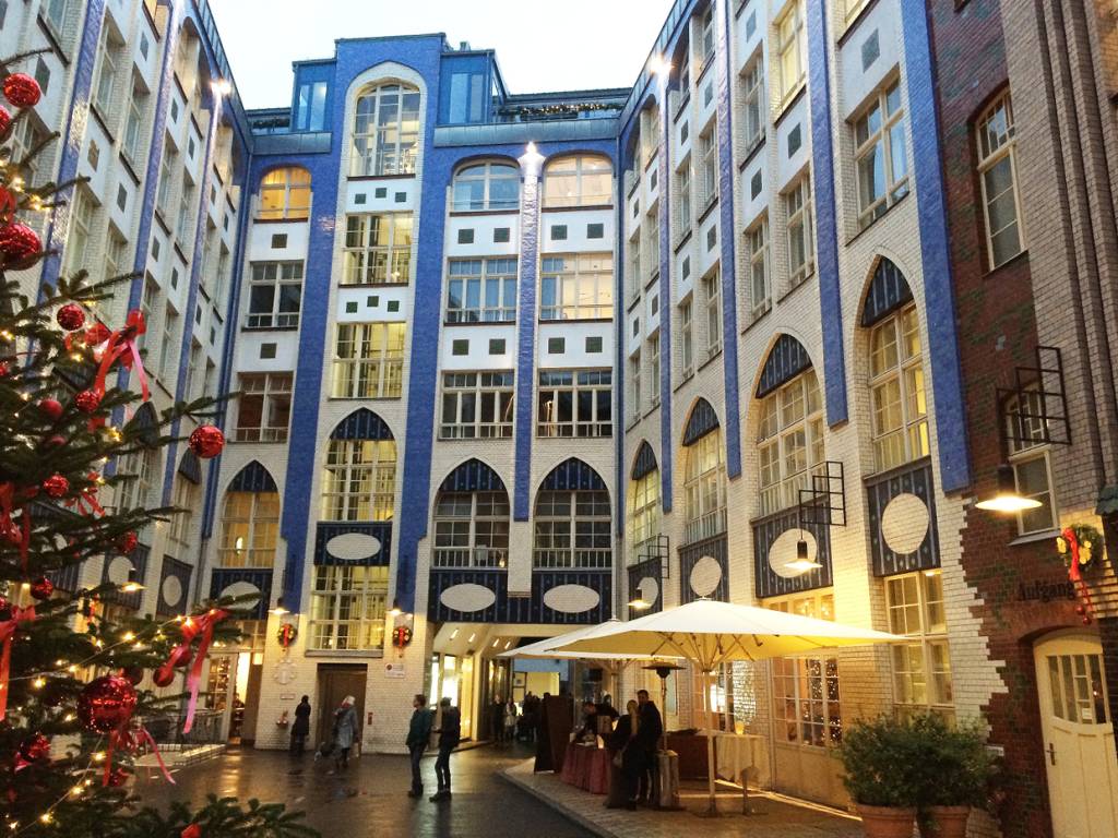 Hackescher Höfe em Berlim. Arquitetura em tons de branco e azul e enfeites natalinos