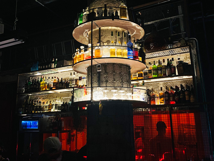 Torre de concreto, acondiciona bebidas no centro do balcão do Regô bar.