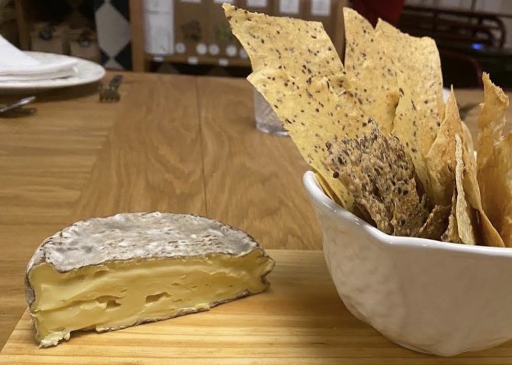 Queijo e crackers em fundo de madeira