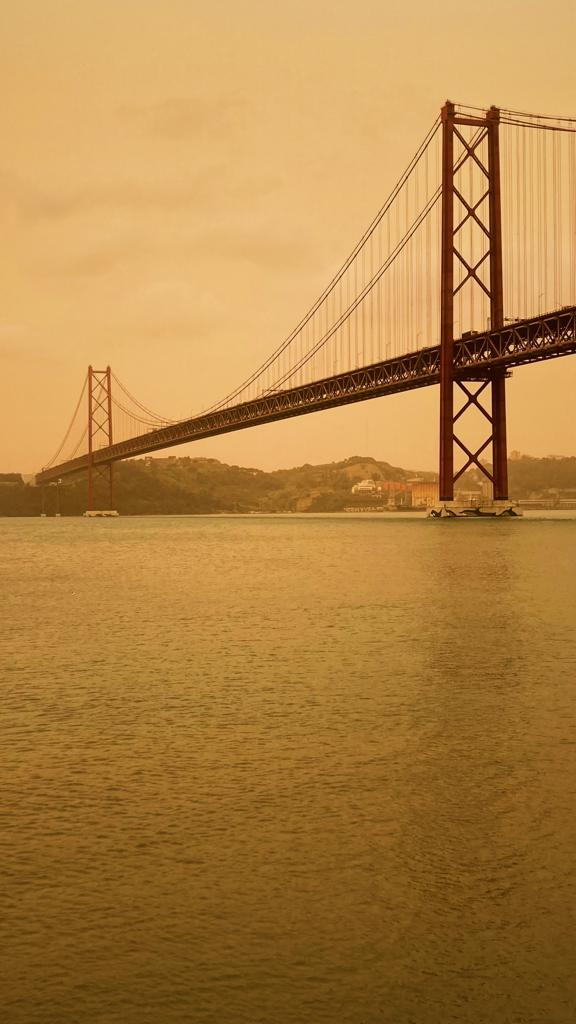 A Ponte 25 de Abril, em Lisboa, com o céu completamente amarelo